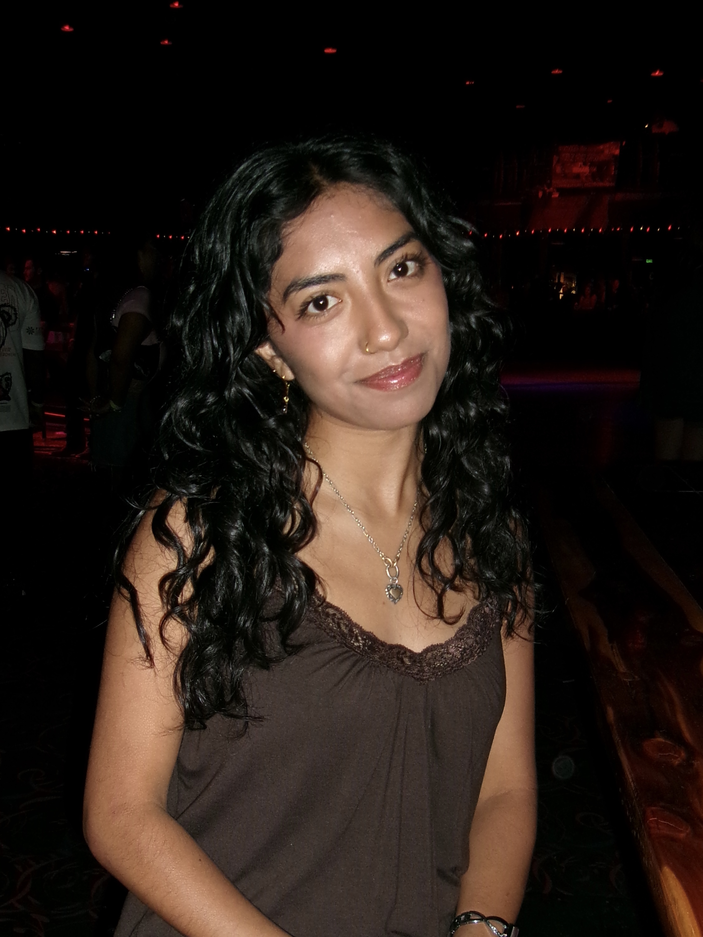 Photo of mayah sitting down in a brown shirt.